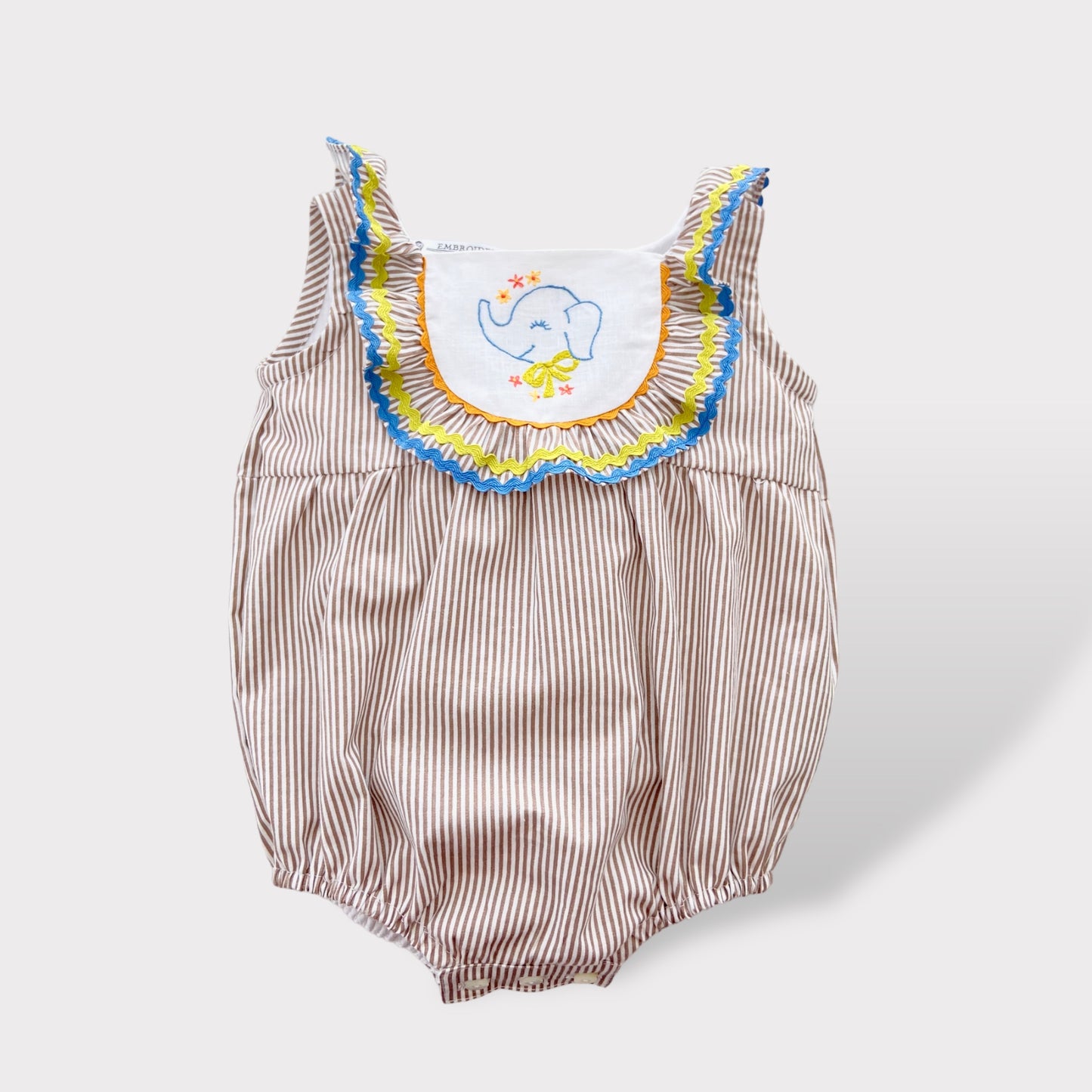 Pagliaccetto in cotone a righe tortora e bianco con pettorina in puro lino bianco e ricamo di un piccolo elefantino. Il pagliaccetto per neonato realizzato in fibra naturale ideale per la pelle delicato del neonato.