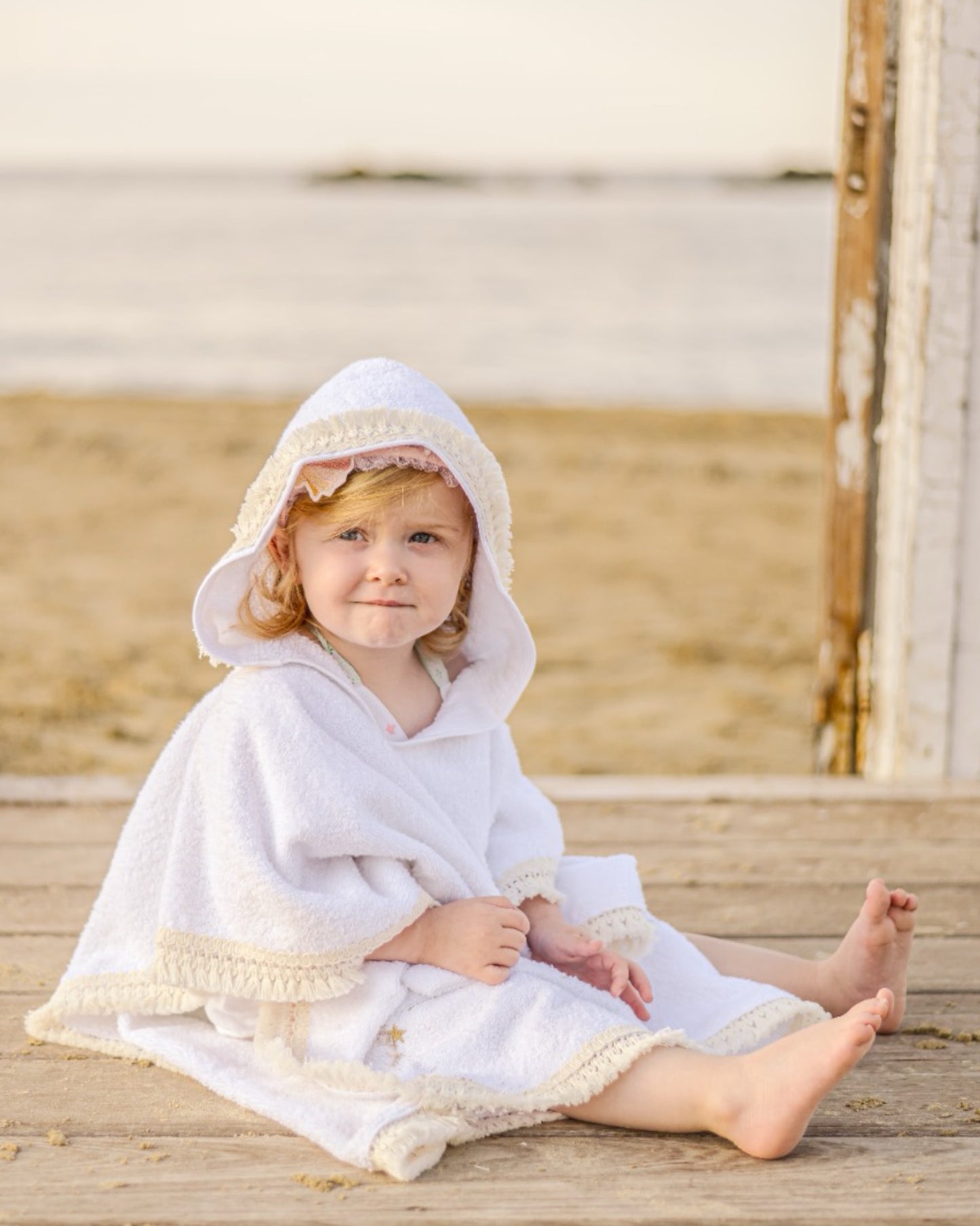 Poncho albornoz de rizo con conchas y estrellas de mar bordadas