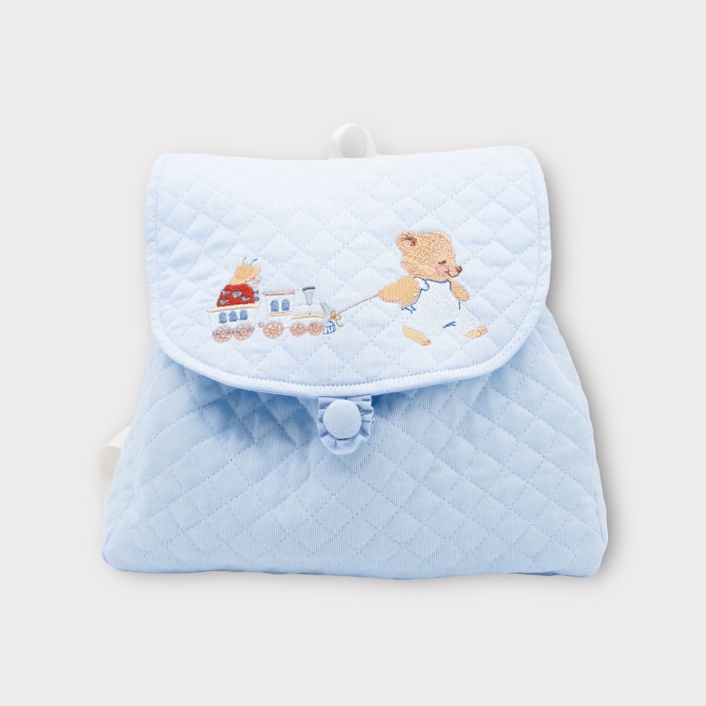 Light blue quilted backpack with teddy bear and train